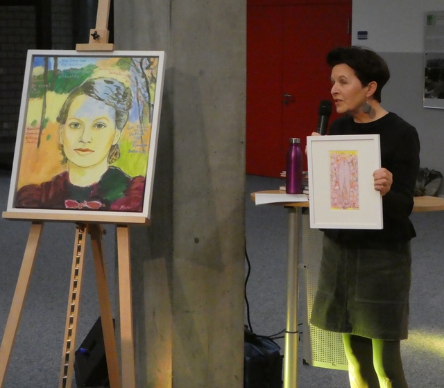 Die Künstlerin Marlis E. Glaser spricht über ihre Bilder. Links das Porträt von Lisa Frank. Foto: Edenhofer